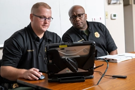 gwinnett county fire emergency services employees looking at laptop computer