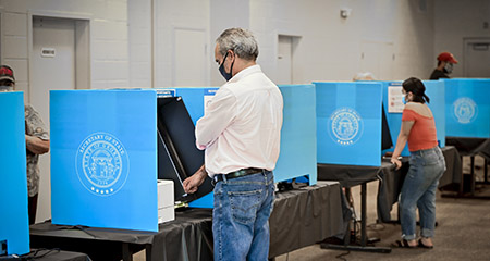 citizens casting vote in voting booth