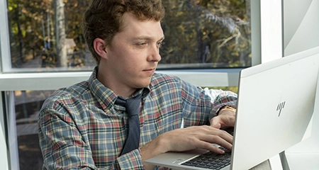 man typing on laptop
