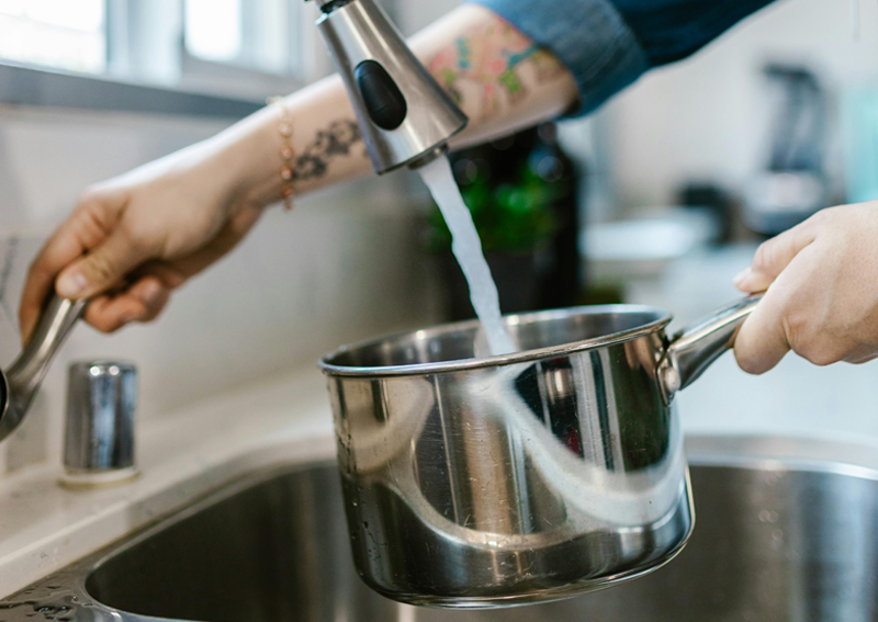 woman filling up pot of water