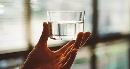 hand holding glass of water
