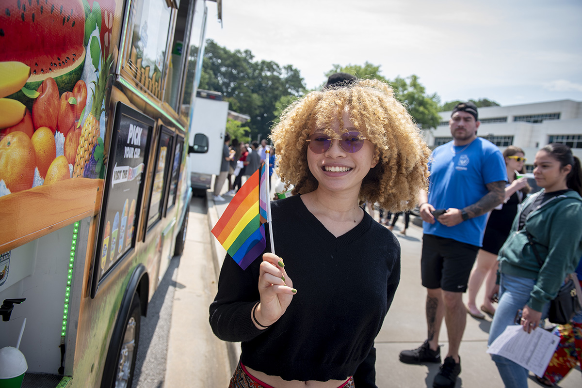 Light skin female holding the pride flag