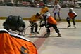 Children playing hockey with full pads, helmets and ice skates
