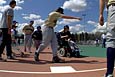 Person in a wheelchair rounding the bases on a baseball field