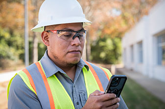 Construction worker looking at cell phone